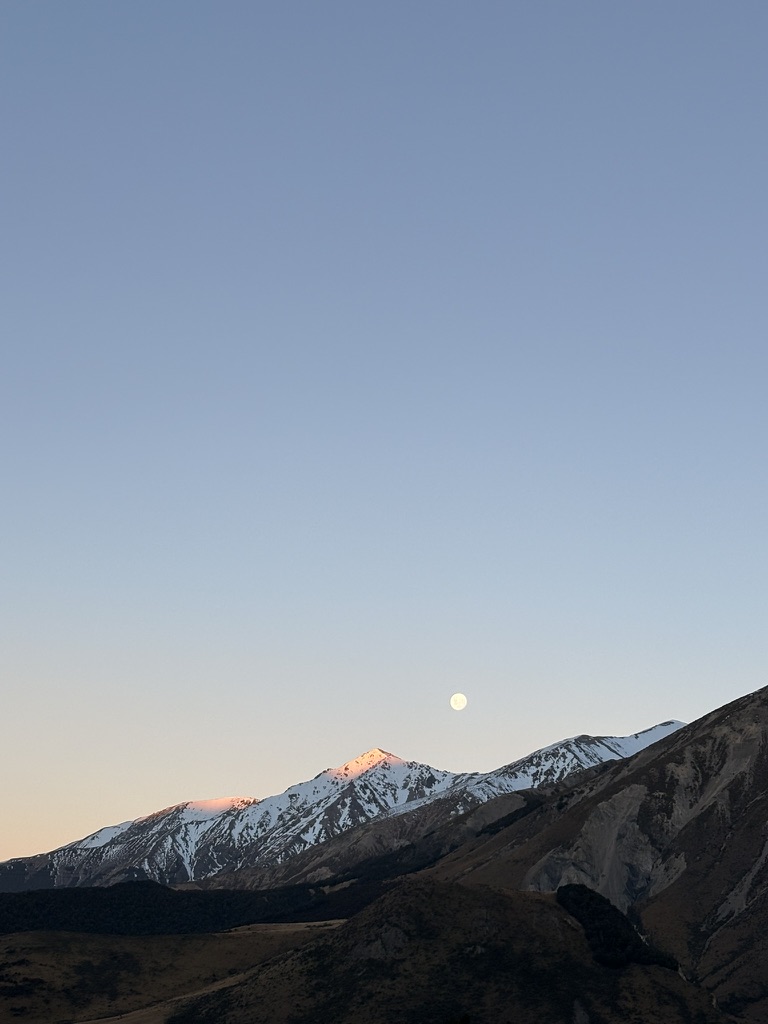 Moonrise over snow-covered New Zealand mountains